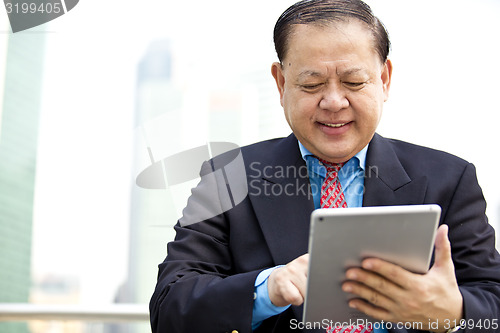 Image of Asian businessman using tablet