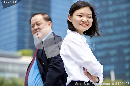 Image of Asian businessman and young female executive smiling portrait