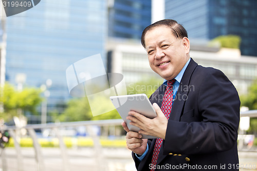 Image of Asian businessman using tablet