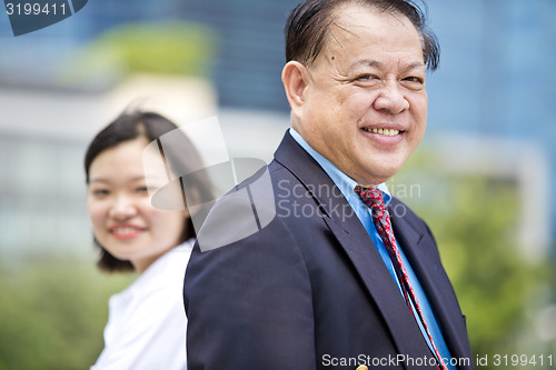 Image of Asian businessman and young female executive smiling portrait