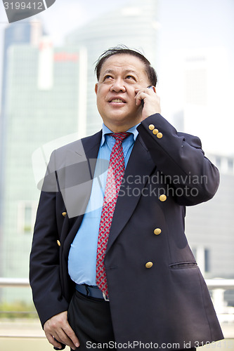 Image of Asian businessman talking on smart phone