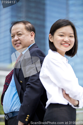 Image of Asian businessman and young female executive smiling portrait