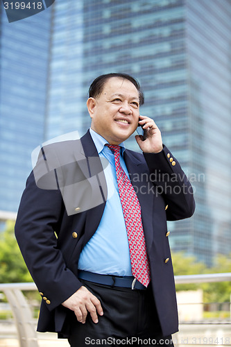 Image of Asian businessman talking on smart phone