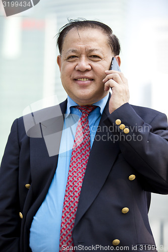 Image of Asian businessman talking on smart phone