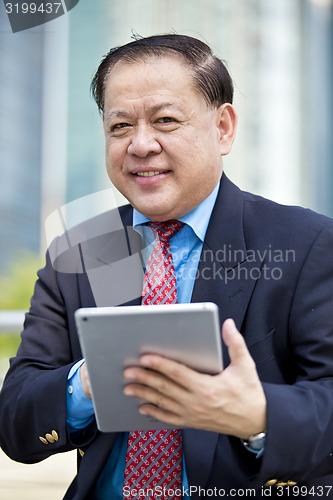 Image of Asian businessman using tablet