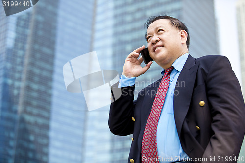 Image of Asian businessman talking on smart phone