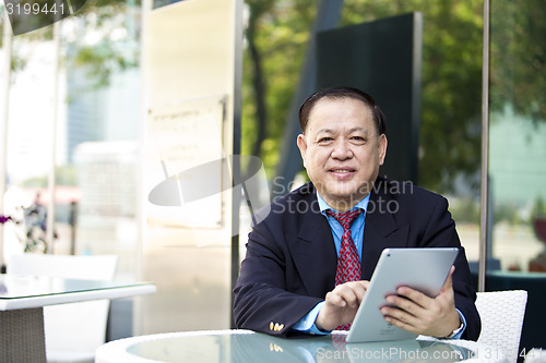 Image of Asian businessman using tablet