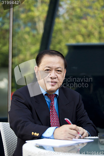 Image of Asian businessman writing proposal