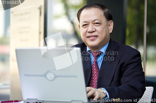 Image of Asian businessman using laptop