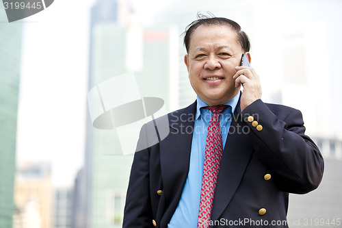 Image of Asian businessman talking on smart phone
