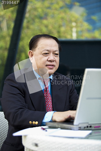 Image of Asian businessman using laptop