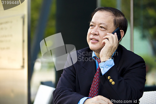 Image of Asian businessman talking on smart phone