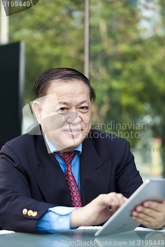 Image of Asian businessman using tablet