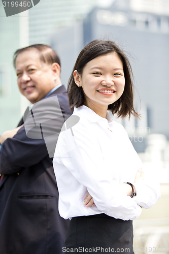 Image of Asian businessman and young female executive smiling portrait