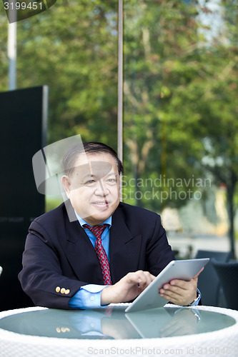 Image of Asian businessman using tablet