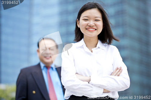 Image of Asian businessman and young female executive smiling portrait