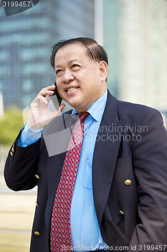 Image of Asian businessman talking on smart phone