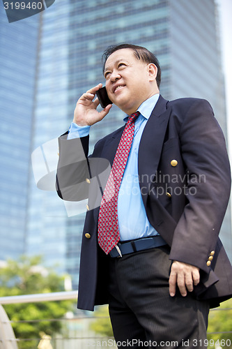 Image of Asian businessman talking on smart phone