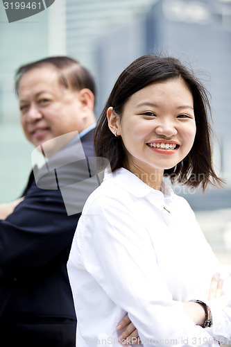 Image of Asian businessman and young female executive smiling portrait