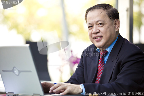 Image of Asian businessman using laptop