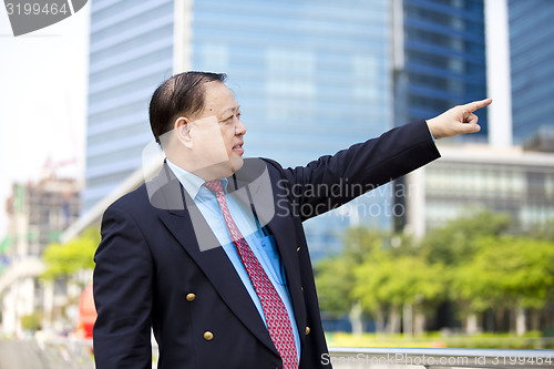 Image of Asian businessman pointing at a direction