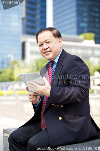 Image of Asian businessman using tablet