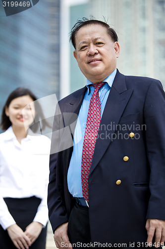 Image of Asian businessman and young female executive smiling portrait