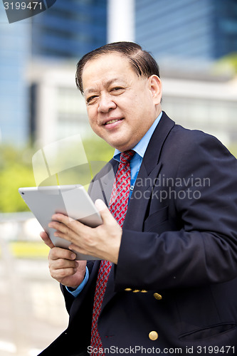 Image of Asian businessman using tablet