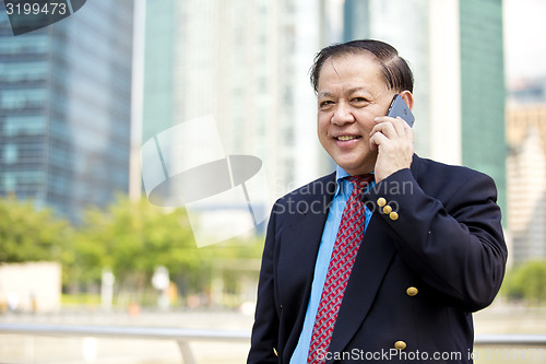 Image of Asian businessman talking on smart phone