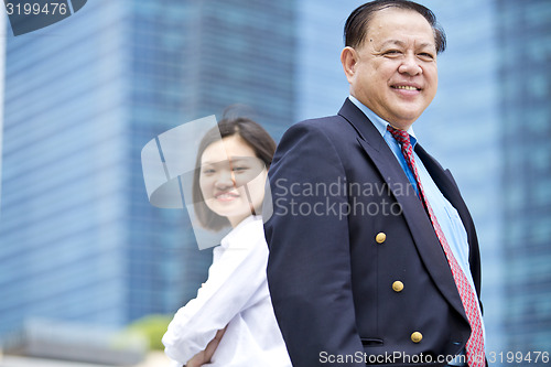 Image of Asian businessman and young female executive smiling portrait