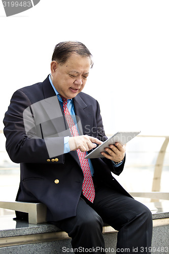 Image of Asian businessman using tablet