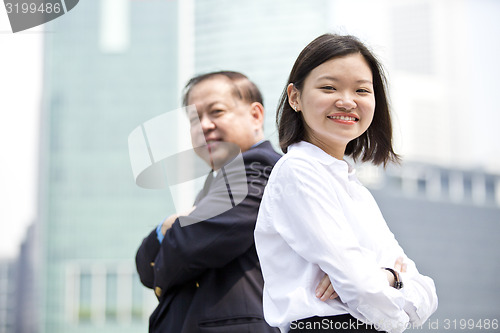 Image of Asian businessman & young female executive smiling portrait