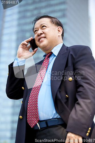 Image of Asian businessman talking on smart phone