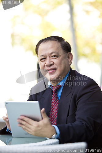 Image of Asian businessman using tablet