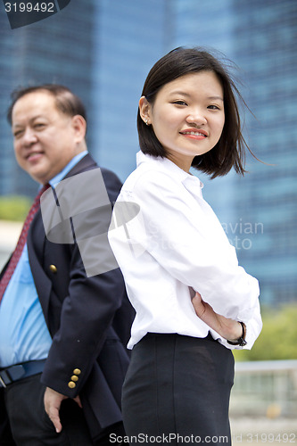 Image of Asian businessman & young female executive smiling portrait