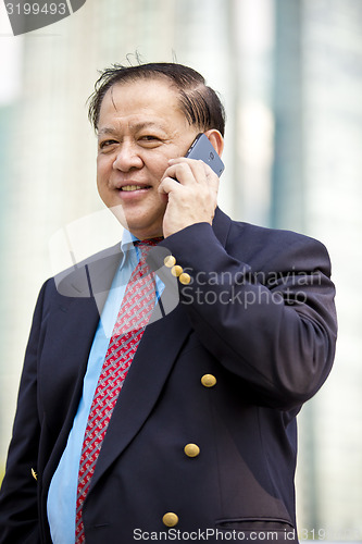 Image of Asian businessman talking on smart phone