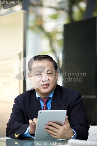 Image of Asian businessman using tablet