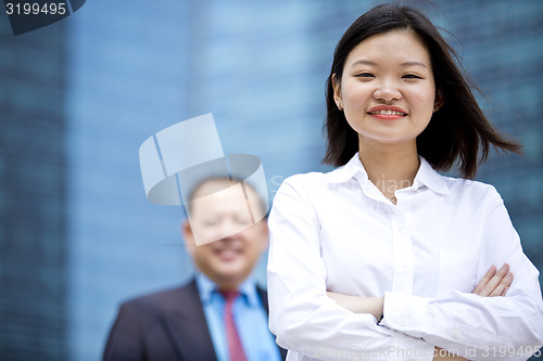 Image of Asian businessman & young female executive smiling portrait