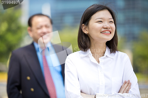 Image of Asian businessman & young female executive smiling portrait