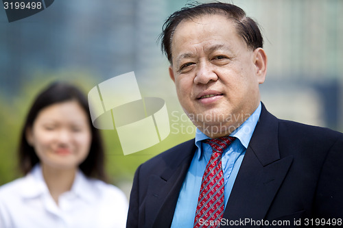 Image of Asian businessman & young female executive smiling portrait