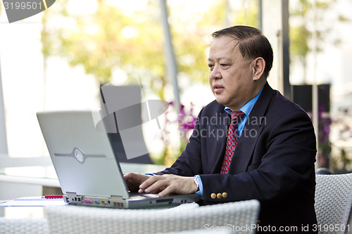 Image of Asian businessman using laptop