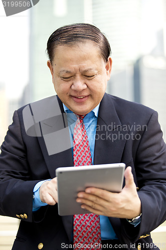 Image of Asian businessman using tablet