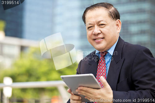 Image of Asian businessman using tablet