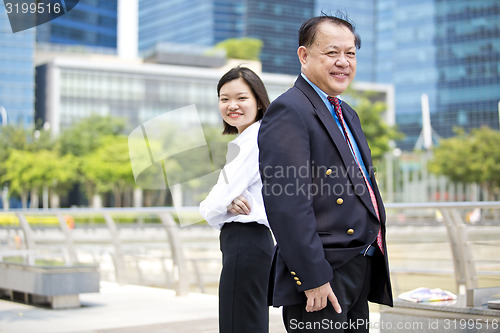 Image of Asian businessman & young female executive smiling portrait