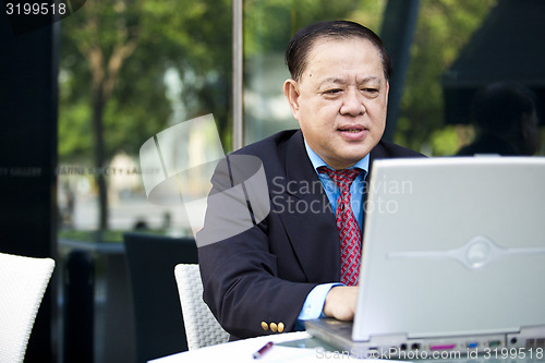 Image of Asian businessman using laptop