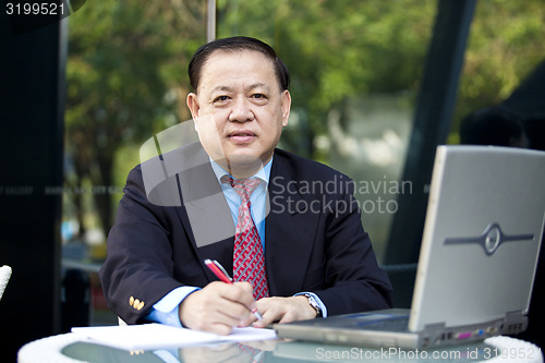 Image of Asian businessman writing proposal