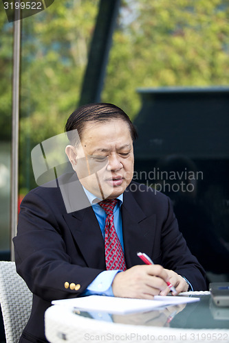 Image of Asian businessman writing proposa