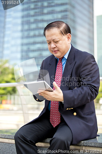 Image of Asian businessman using tablet