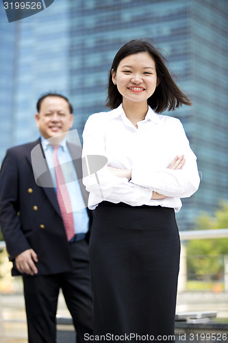 Image of Asian businessman & young female executive smiling portrait