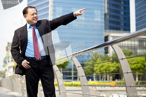 Image of Asian businessman smiling pointing at a direction